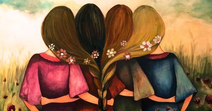 Four women with hair all braided together.