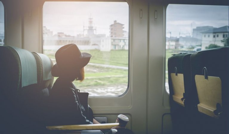 A girl is sitting on board a train.