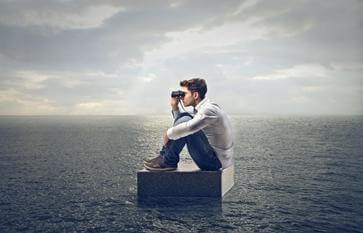 A boy looking through binoculars in an ocean.