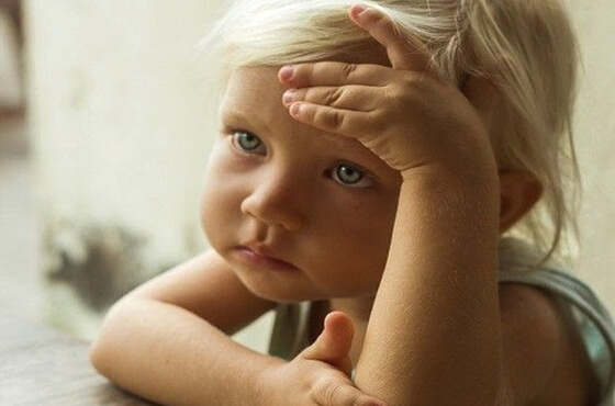 A sad blond child is worried.