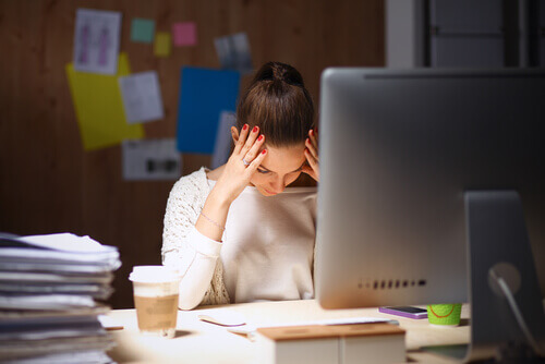 A woman is stressed at her work desk.