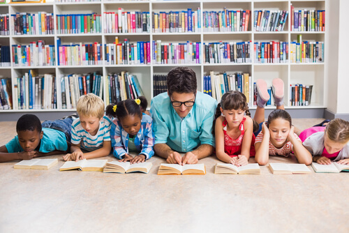 a teacher with his students reading books