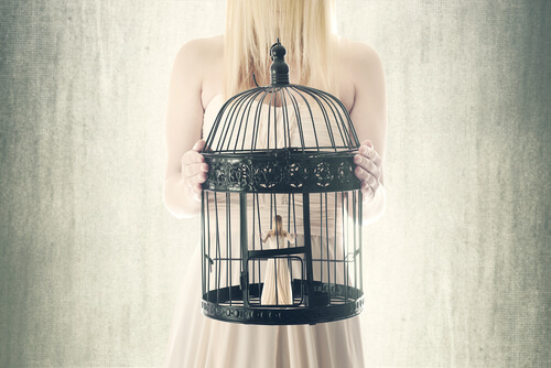 a girl holding a birdcage with herself inside