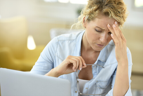 a woman at her laptop, upset