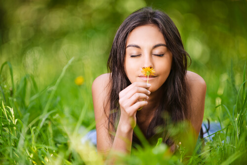 woman smelling flower thinking about living in the present