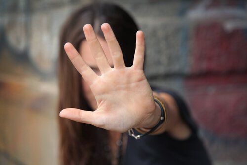 A woman holding her hand up to say STOP.