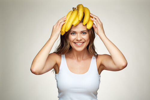 A woman holding bananas on her head.