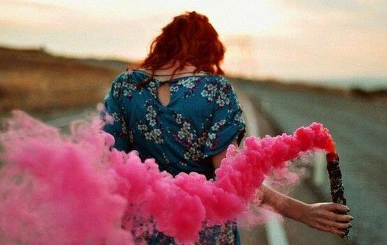 Woman with trail of pink smoke