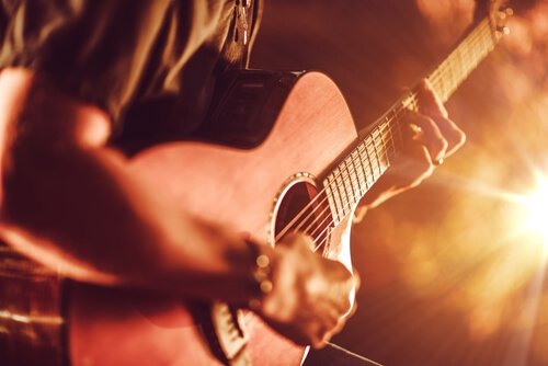 Playing the guitar in front of an audience.