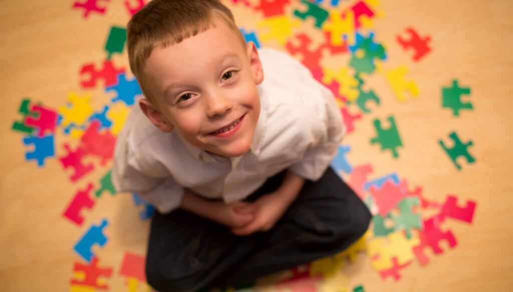 A child with autism and puzzle pieces.