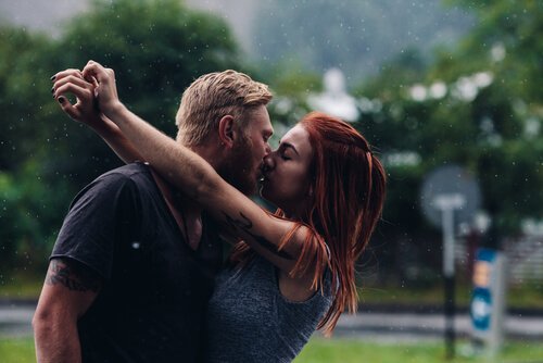 A couple kissing in the rain.