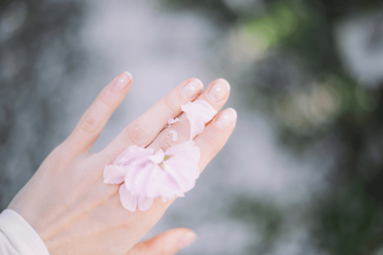Hand with a pale flower on it.