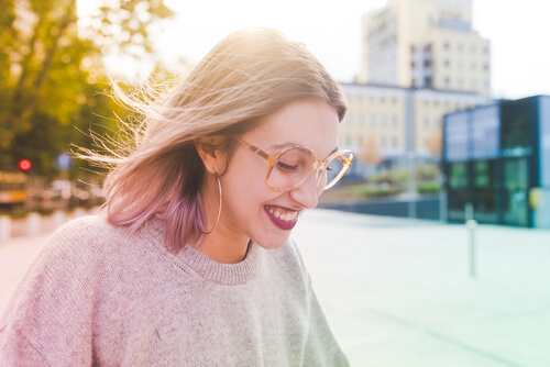 Happy girl with glasses smiling.