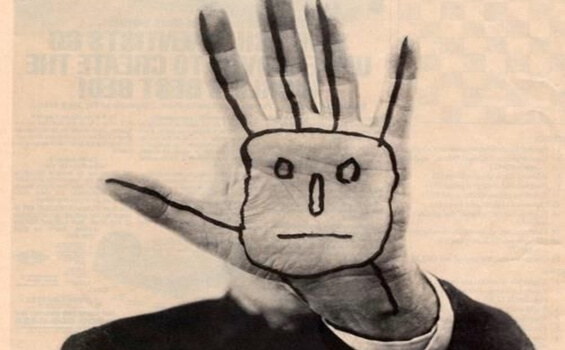 A hand saying stop with a face drawn onto it.