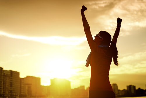 A woman connecting with passion, arms up in victory.