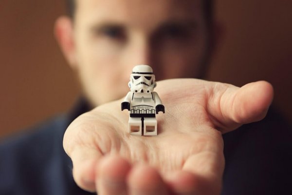 Holding a robot toy LEGO in a hand.