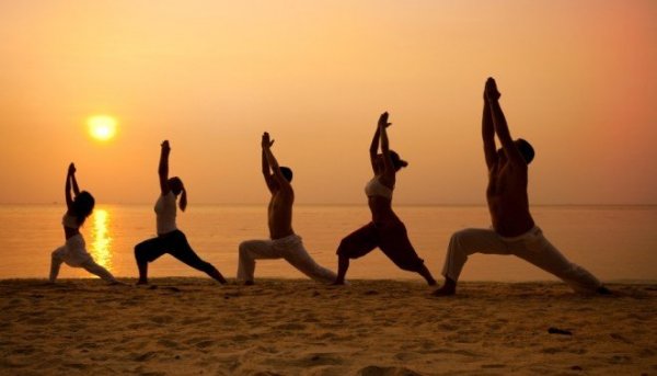 People practicing tai chi on the beach.