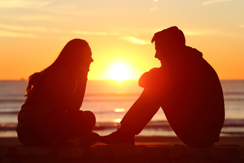 Active listening between friends on the beach at sunset.