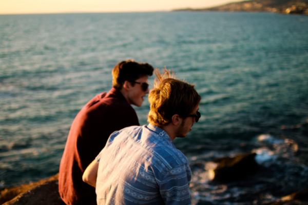 Two men talking by the sea
