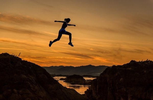 A woman becoming stronger emotionally, leaping over the mountains.