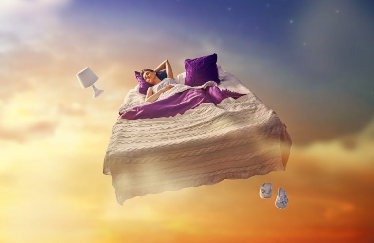 A woman is sleeping in a bed in the clouds.