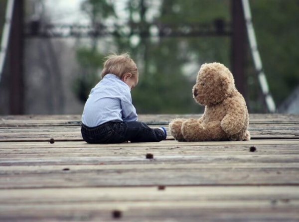 A baby's development: baby and teddy bear.
