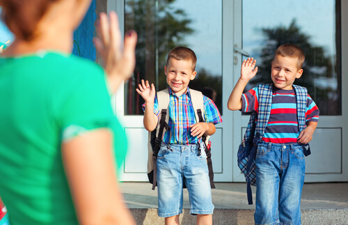 Goodbye at school, a mother waving to her sons.