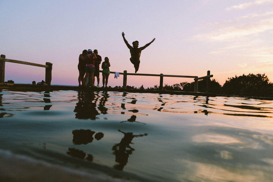 First times: a man diving into the water with friends.
