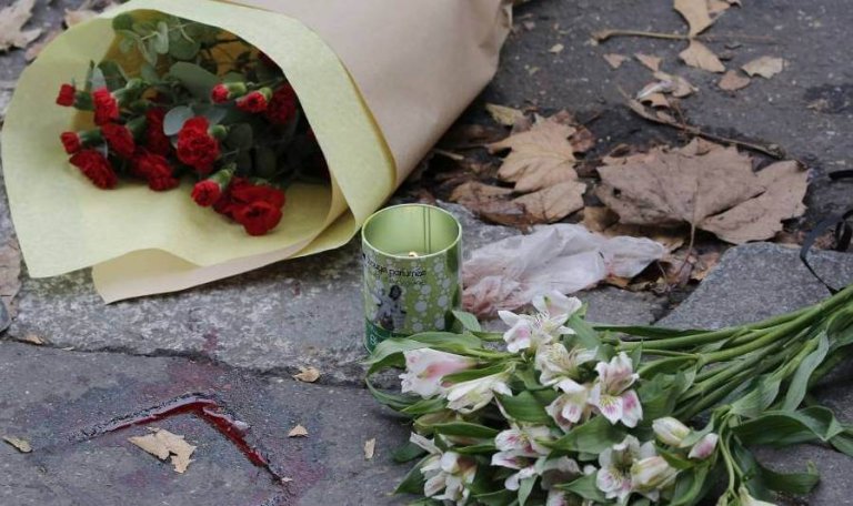 Flowers and a candle on the street after terrorism.