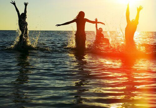 Lonely in the middle of a crowd: friends in the ocean playing happily.