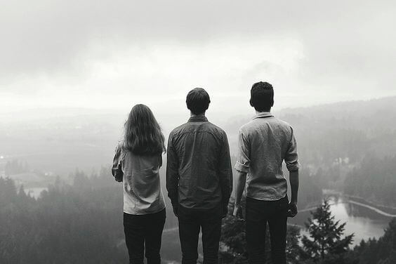 Three friends looking with collective nostalgia at the foggy valley.