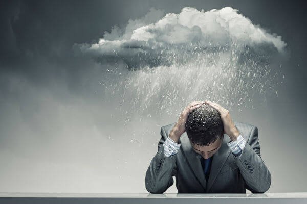A storm cloud raining over a man in a suit.