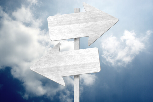 Two arrow signs pointing in opposite directions to make a decision