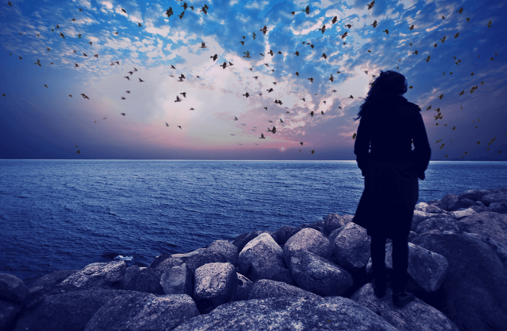 Woman gazing out at the ocean feeling negativity.