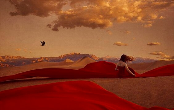 Woman with red dress in desert