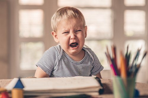 a child is crying and screaming, throwing tantrums.