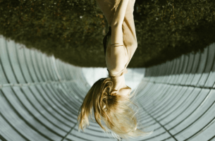 A girl with windy hair upside down.