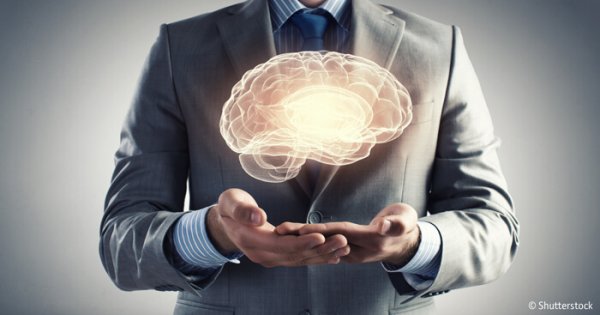 a-man-holding-up-a-figure-of-a-brain A man holding up a figure of a brain.