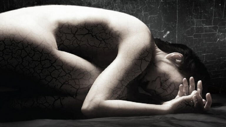 a woman with fragmented skin crumpled on the ground