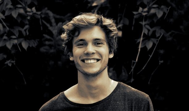 A young man is smiling.