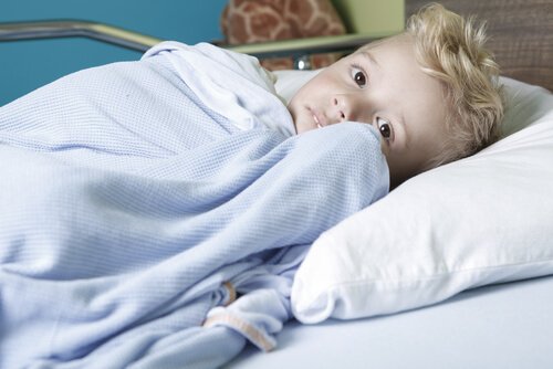 A boy with cancer is in a hospital bed.