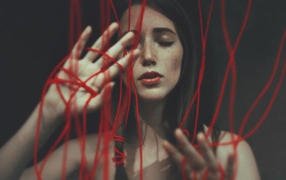 A woman tangled in red cords.