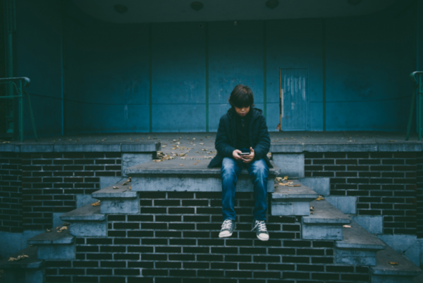 A child sitting in the dark on steps.