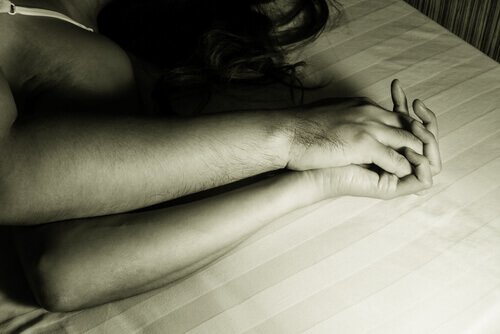 Couple holding hands in bed
