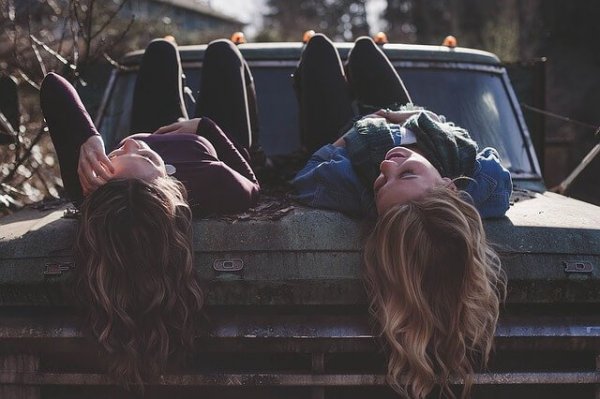 A true friendship: two friends laying on a truck.