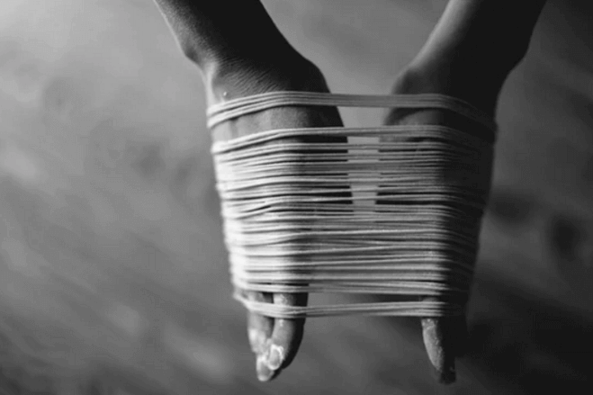 Hands bound with strings.