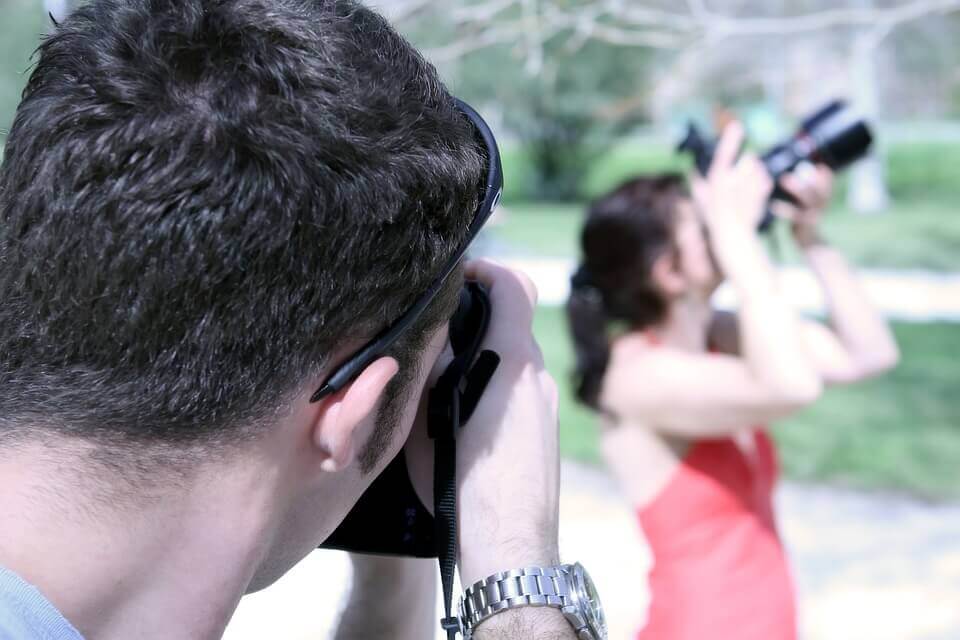 A man taking a photo of a woman taking a photo: elicitation