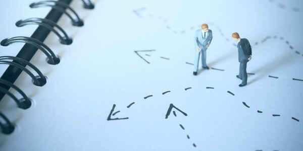 two men figures on notebook symbolizing reversible thinking