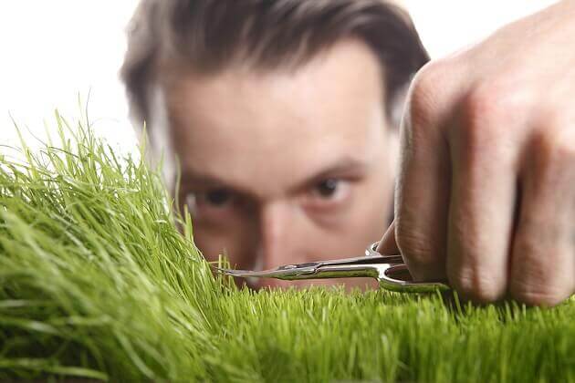 A man with obsessive personality disorder trimming grass.