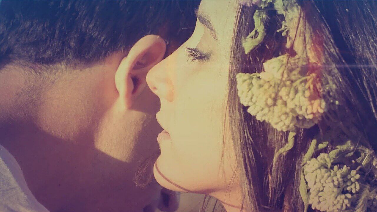 Seduction, a woman whispering into a man's ear.